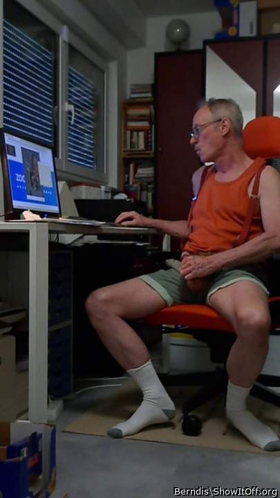 wanking ion green shorts and ornage shirt looking at the PC