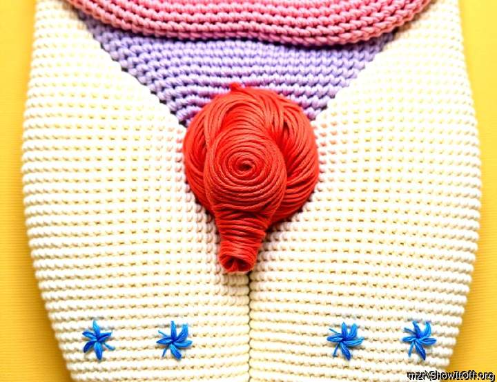 Stylized,  depiction of the uncut foreskin, created from yarn in various colors.